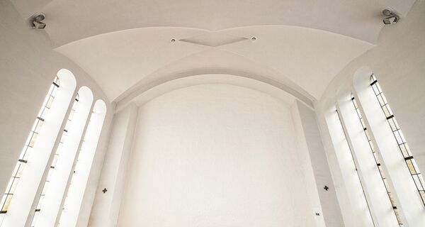 Wit gespoten gewelf van een kerkinterieur
